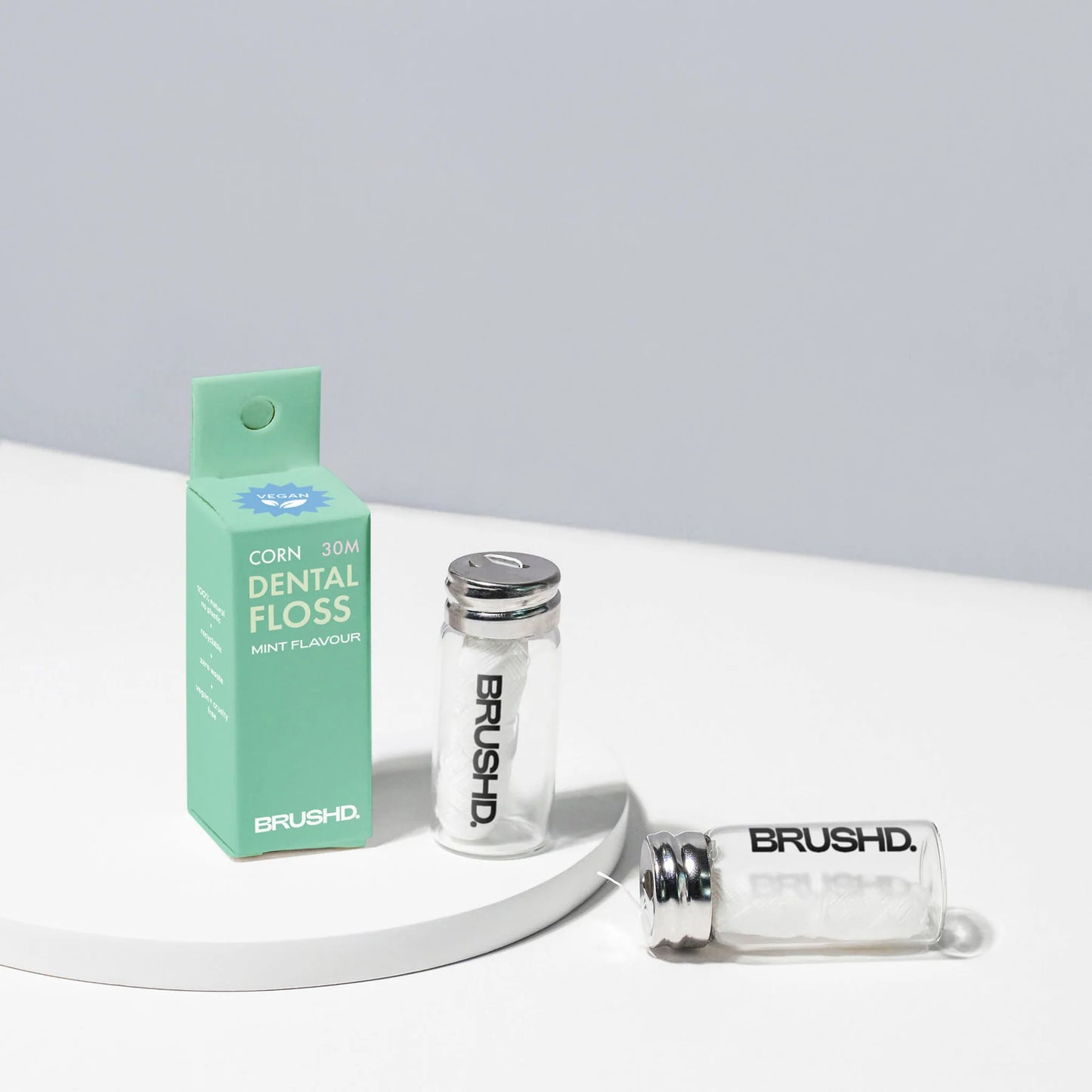 Brushd cornstarch dental floss 2 x glass dispensers and a green box