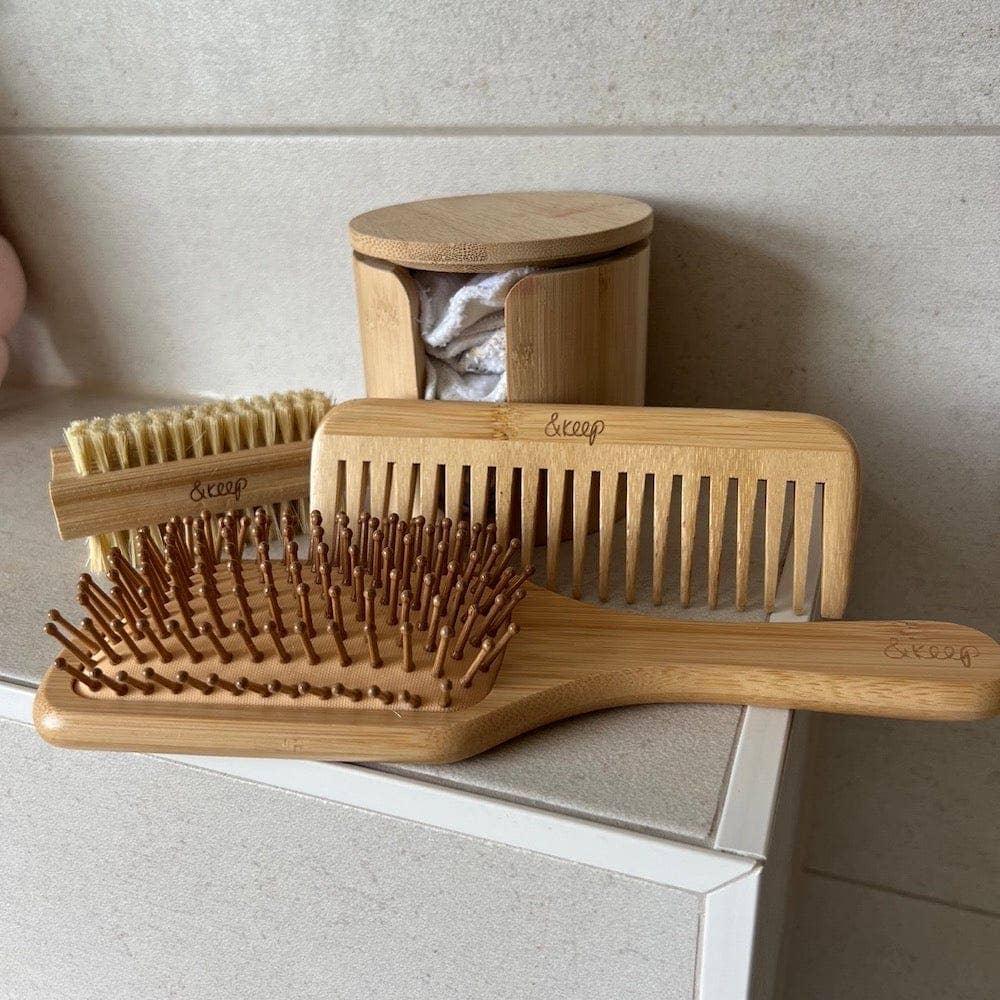 Set of wooden hairbrushes and comb on a neutral background
