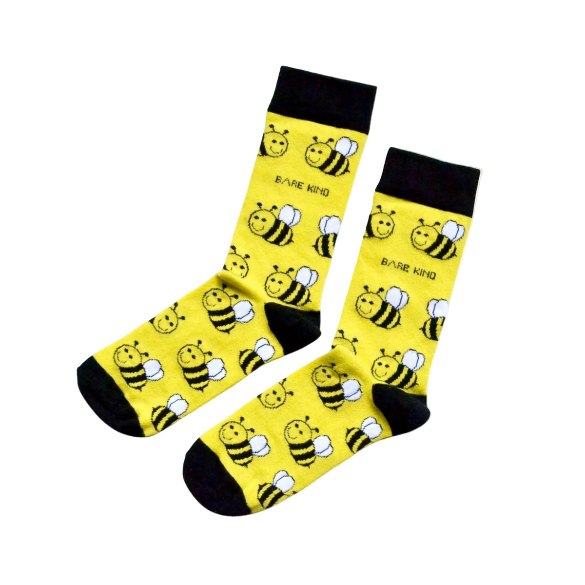 A pair of yellow crew socks with a black cuff, heel, and toe, featuring a repeating pattern of cartoon busses and the text 'BARE KIND'.