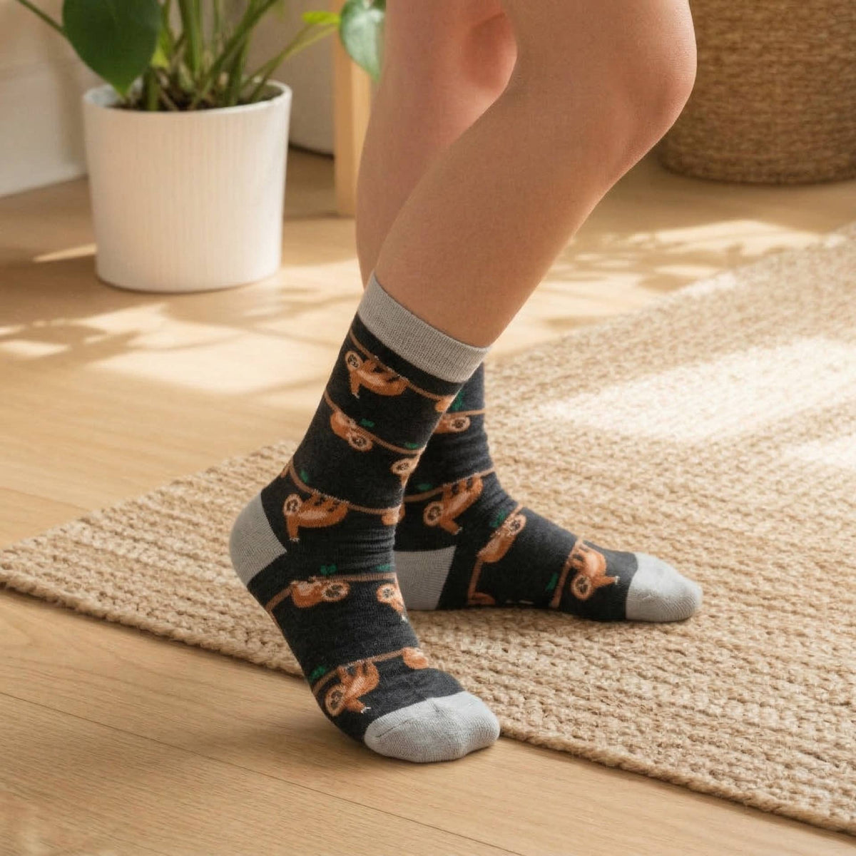 Person wearing socks with slow loris pattern on a wooden floor