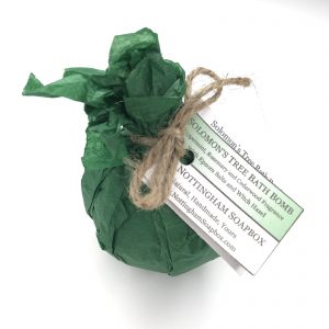 A green tissue-wrapped bath bomb with a twine bow and a hanging paper tag reading 'Nottingham Seaplex' and 'Solomon's Tree Bath Bomb,' shown on a white background.