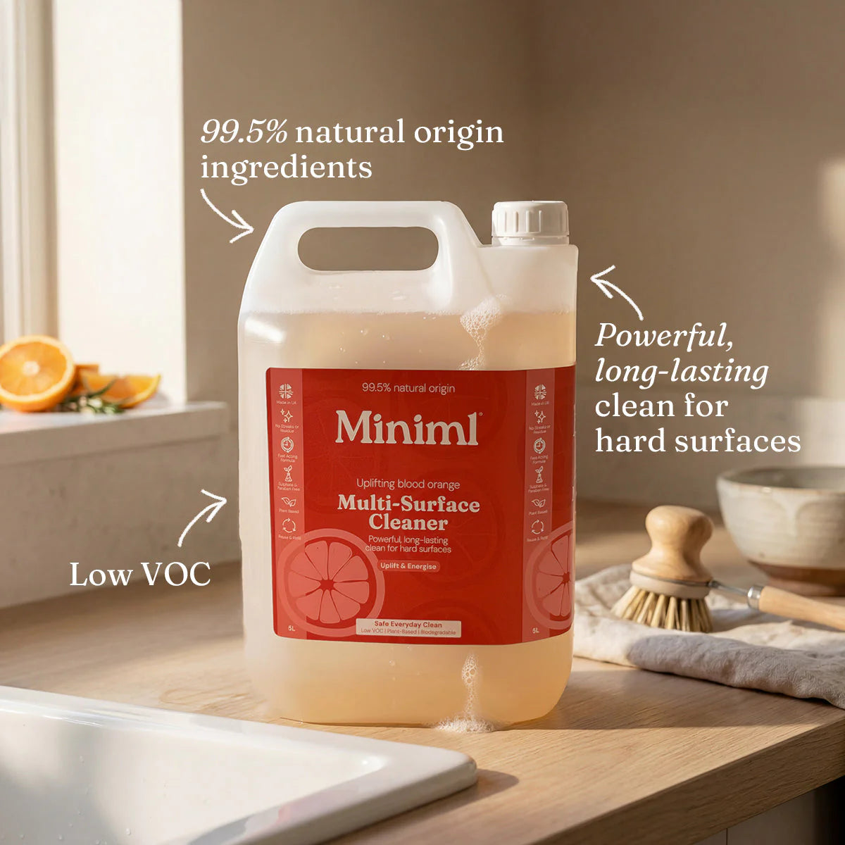 Miniml multi-surface cleaner bottle on a kitchen counter with text highlighting features.