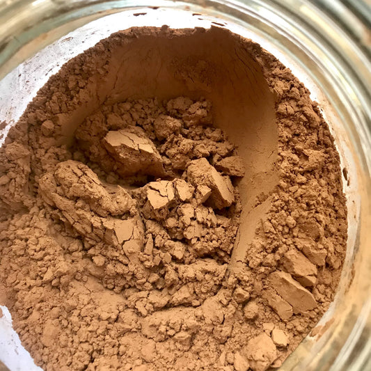Brown coloured cocoa powder in a glass jar