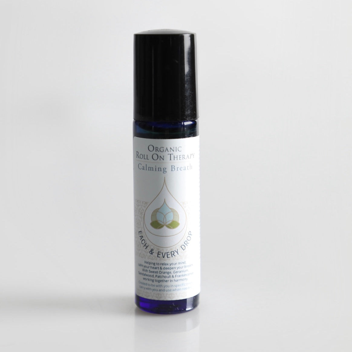Roll-on bottle with black cap and white label on a light gray background