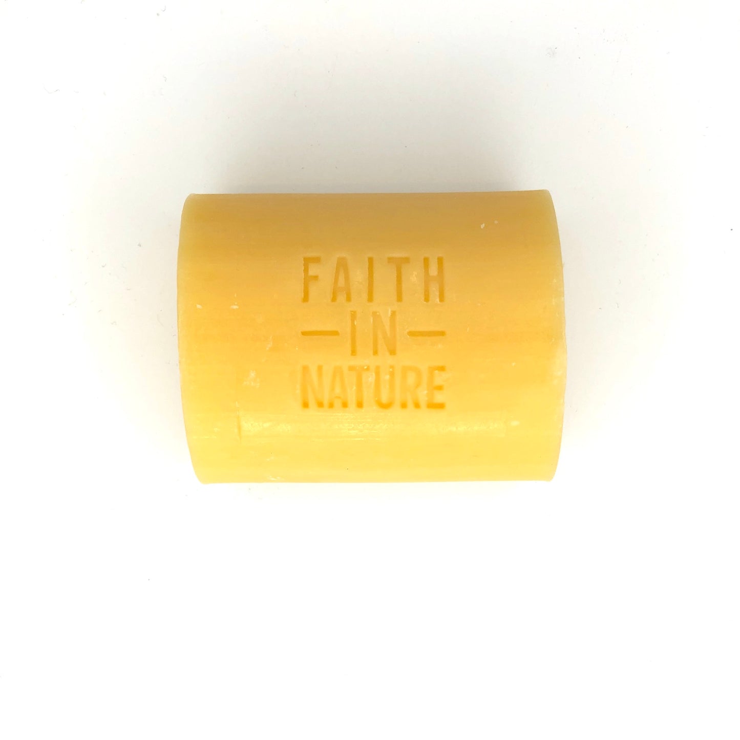 Yellow bar of soap with 'Faith in Nature' branding on a white background