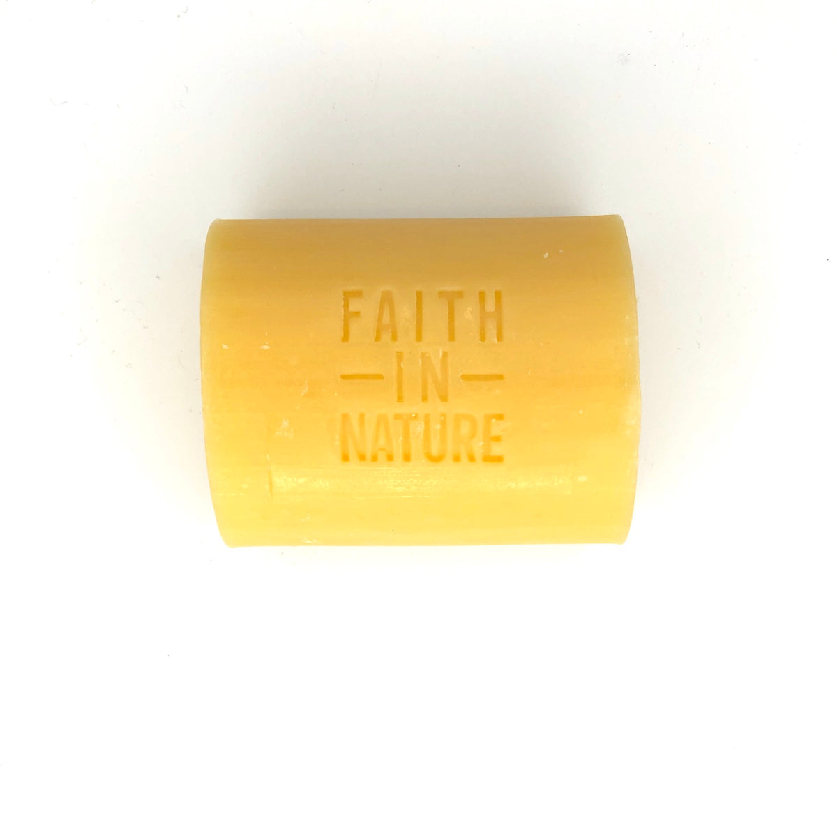 Yellow bar of soap with 'Faith in Nature' branding on a white background