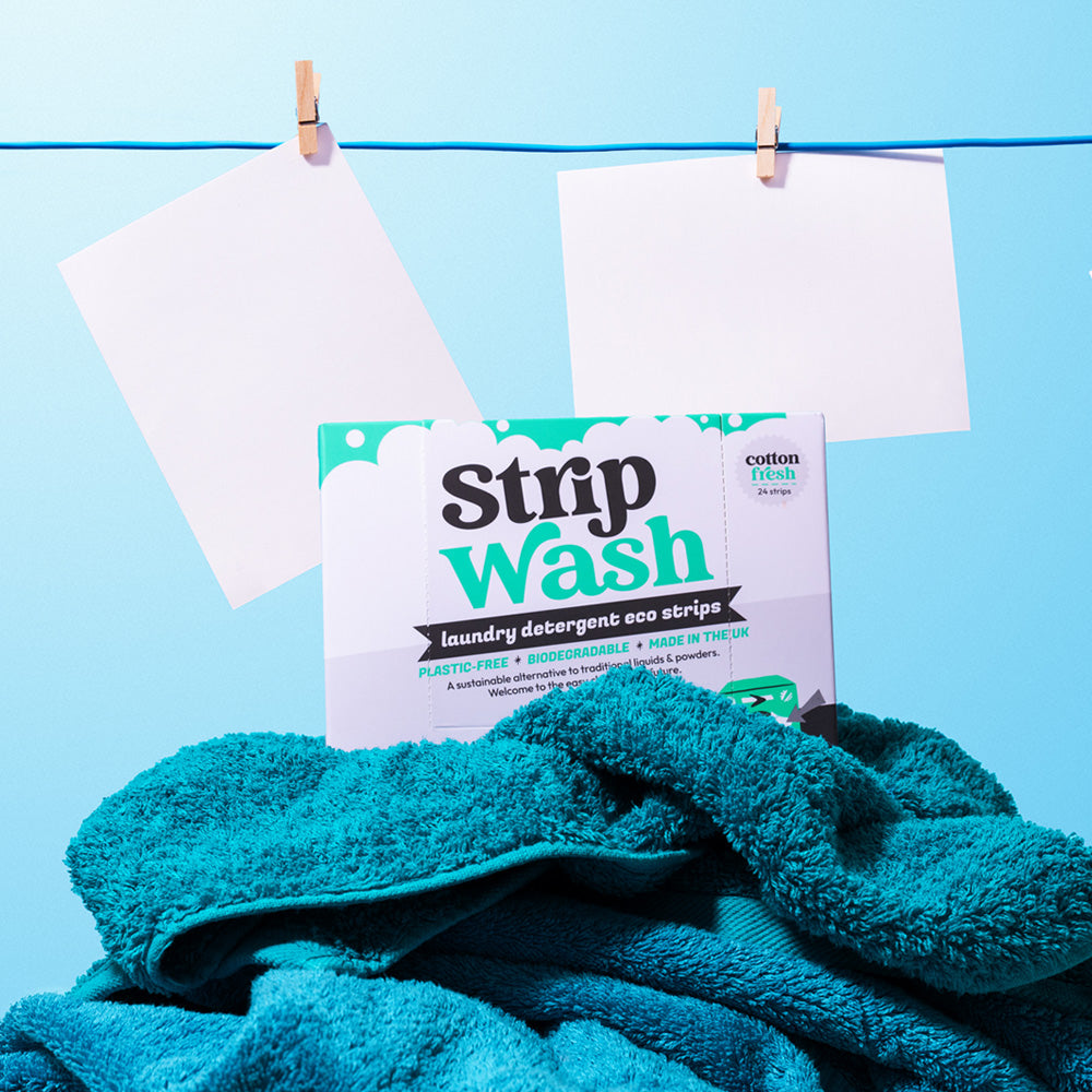 Strip Wash laundry detergent eco strips packaging with teal towels on a blue background