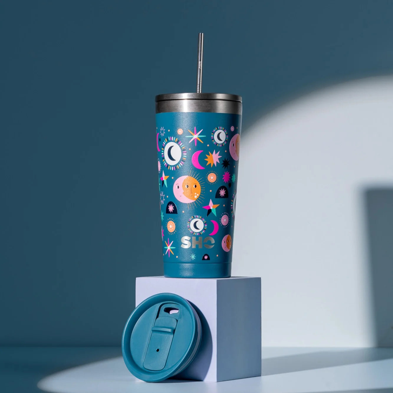 Calix insulated dark blue 500ml reusable cup in Moonlit Night design with stars and moons with a straw lid and showing the 2nd slider lid