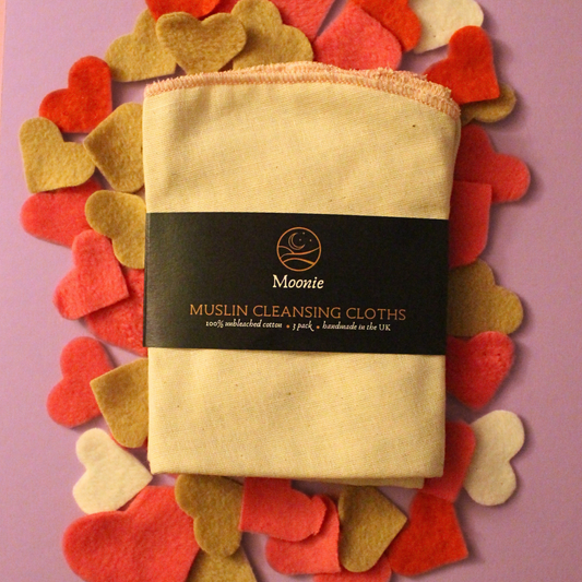 Pack of Muslin Cleansing Cloths with a decorative heart border on a pink background