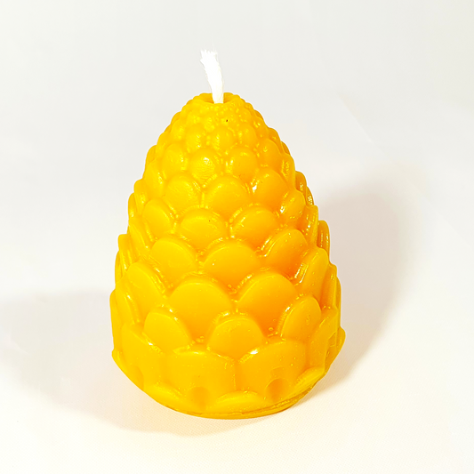 A bright yellow corn-cob-shaped candle with a textured, glossy surface and a white wick at the top, photographed on a clean white background.