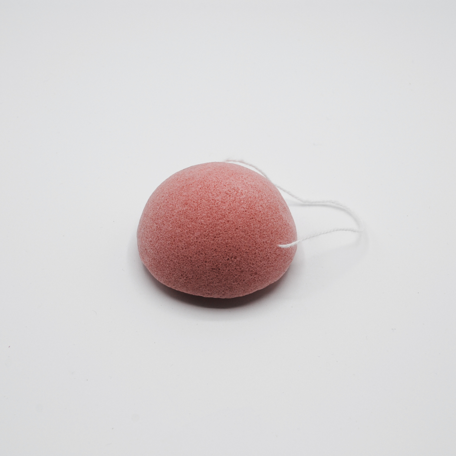 Pink konjac sponge shown on a white background