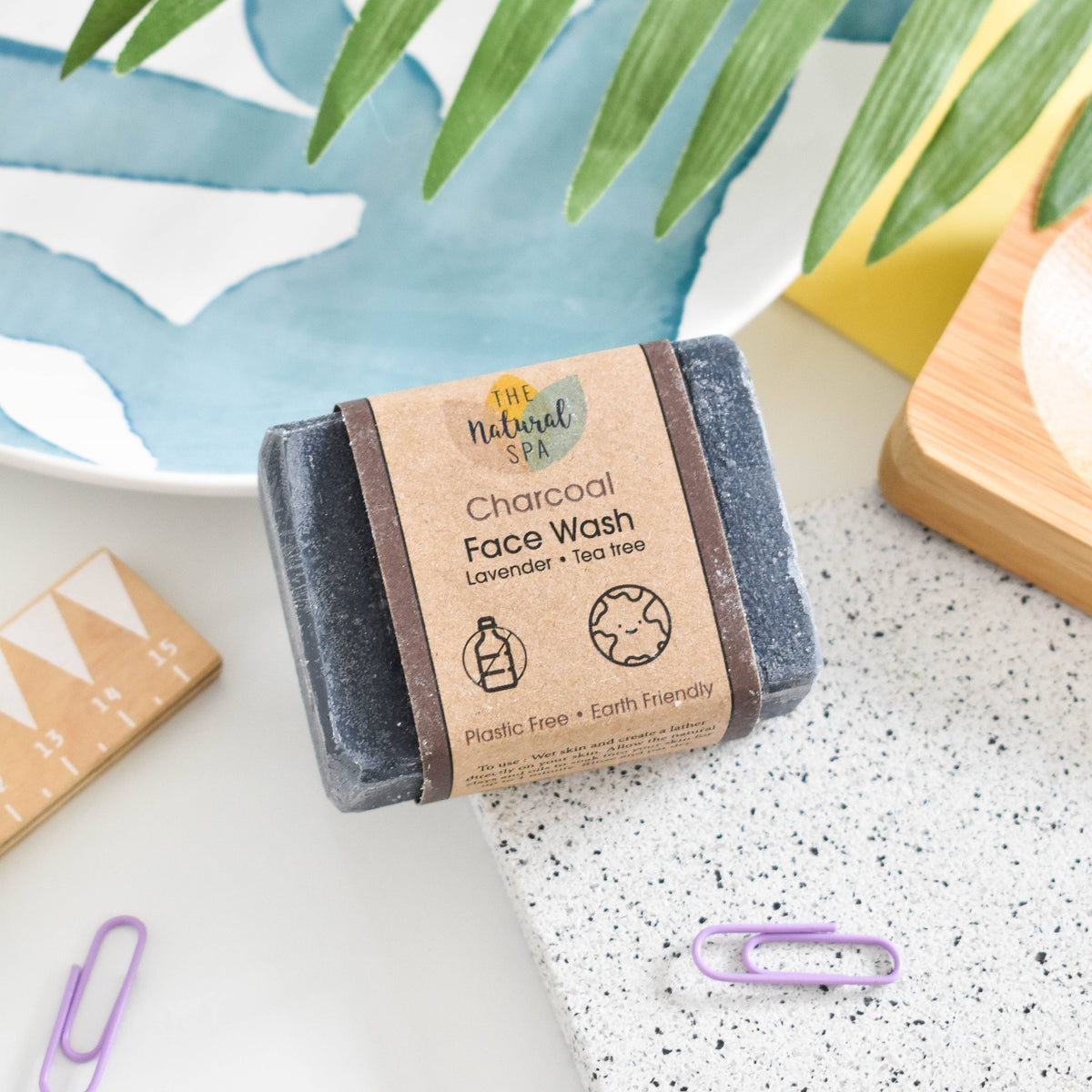 Bar of Charcoal Face Wash with natural packaging on a speckled surface