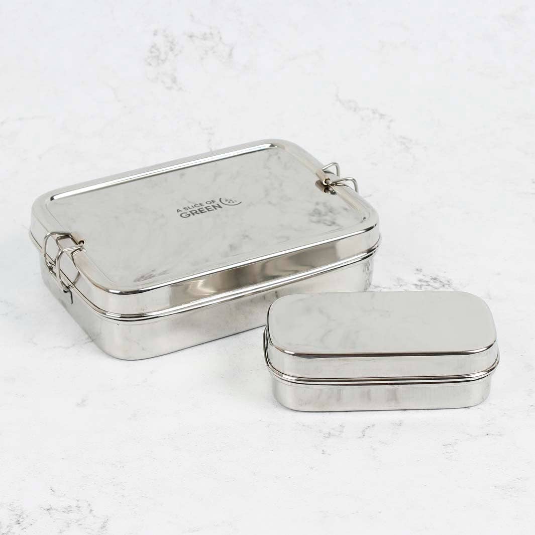 A rectangular stainless steel lunch boxe with a smaller stainless steel insert container shown on a  subtle white marble background. 