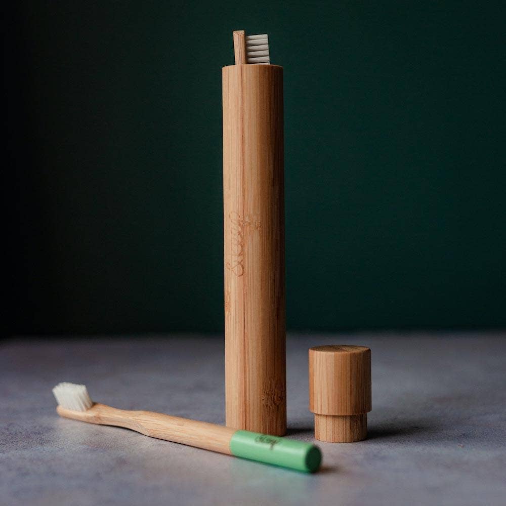 Bamboo toothbrush and holder set on a dark background