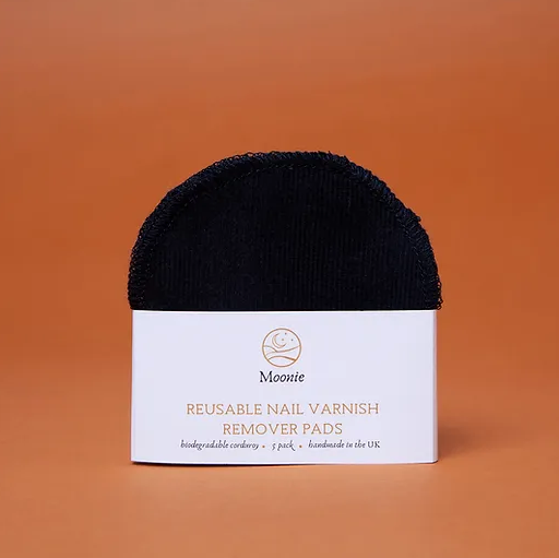 Black reusable nail varnish remover pad with a white label stating 'Moonie' branding against an orange background